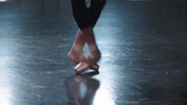 Stüdyoda sivri uçlu ayakkabılarıyla yürüyen profesyonel kadın balerin.