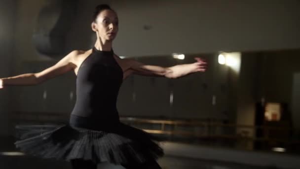 Ballet dansen - vrouw ballerina in zwart tutu sierlijk dansen en spinnen in de lege studio — Stockvideo