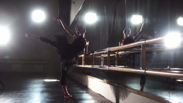 Baile de ballet - bailarina en tutú negro estirándose frente al espejo en el estudio — Vídeos de Stock