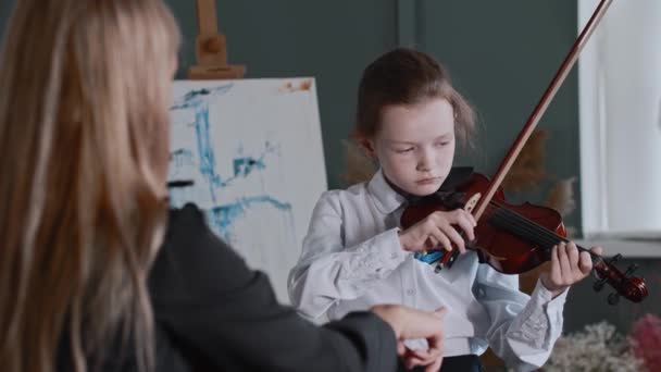 Dziewczyna uczy się grać na skrzypcach ze swoim nauczycielem — Wideo stockowe