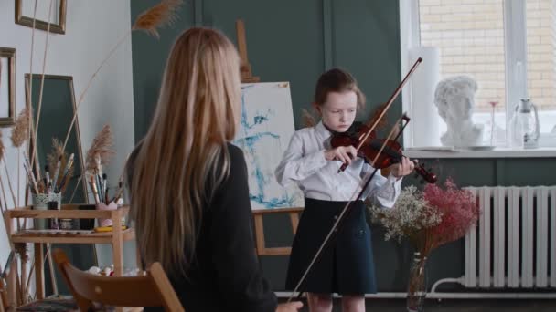 Uma menina aprendendo a tocar violino com sua professora loira na classe — Vídeo de Stock