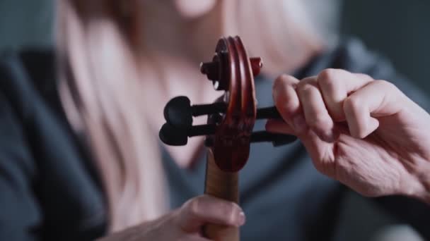 Young blonde woman tuning the violin before playing — Stock Video