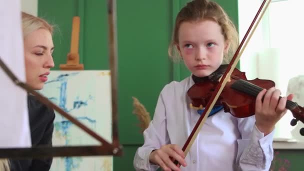 バイオリン教室-ブロンド女性ティーチング女の子バイオリンの遊び方 — ストック動画