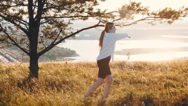 Young woman in a white shirt fencing with a sword on the field — Stock Video