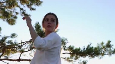 Kılıç eğitimi - beyaz tişörtlü güzel bir kadın doğada akşam vakti kılıç sallıyor.