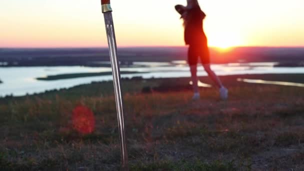 Meče trénink - mladá žena trénink na přírodě při západu slunce - druhý meč vrazil do země — Stock video