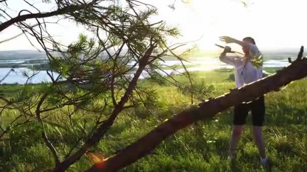 Entrenamiento de espadas - mujer joven agitando con una espada sobre la naturaleza a la luz del día — Vídeo de stock