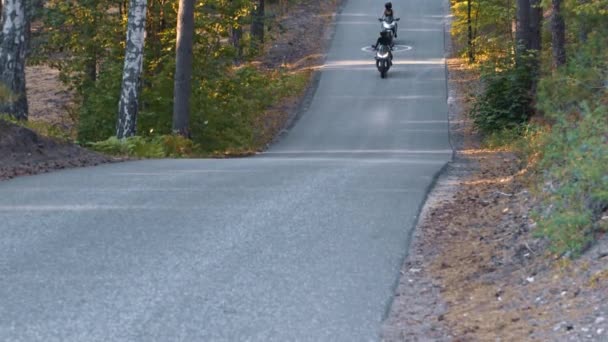 Motorradfahren - zwei Frauen mit Helmen fahren im Wald — Stockvideo