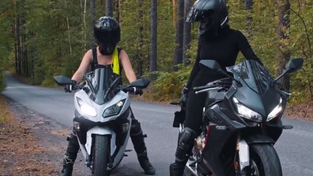 Motorová jízda - dvě ženy v helmách zastaví své motocykly na kraji silnice a dávají si plácnutí — Stock video