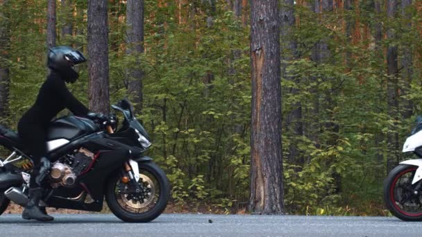 Motorradfahren - zwei Frauen mit Helmen begegnen sich am Straßenrand auf einem Motorrad — Stockvideo