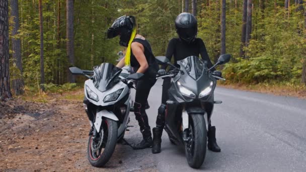 Two adult women friends sits down on their motorbikes and getting ready for the ride — Stock Video