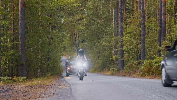 Due donne adulte in moto nella foresta intorno alle auto — Video Stock