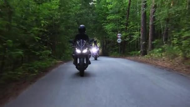 Motos dans la forêt - deux femmes adultes circulant à moto sur la route étroite vide — Video