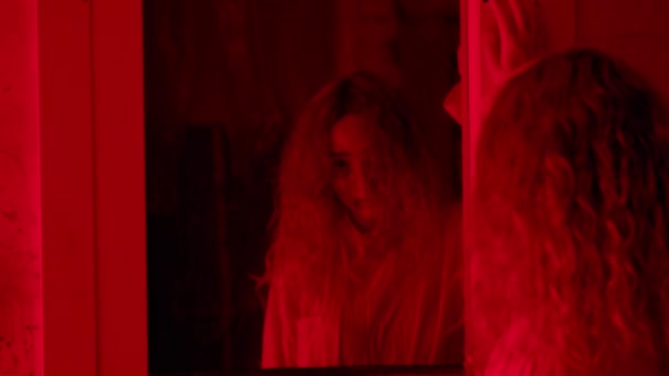 Kvinna i tvångströja står framför en spegel och ser en skrikande man bakom den — Stockvideo