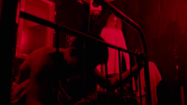 Őrült férfi és nő a szobában piros világítással - elmegyógyintézet — Stock videók