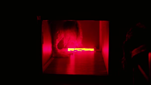 Mujer aterradora en camisa de fuerza arrastrándose en el eje de ventilación en la iluminación roja — Vídeo de stock