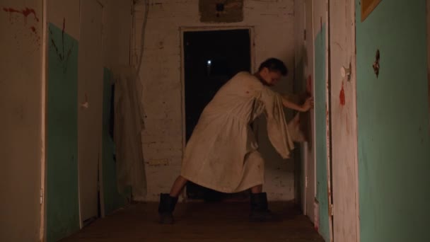 Horror acting - an aggressive man in a straitjacket trying to broke in the room in mental hospital — Stock Video