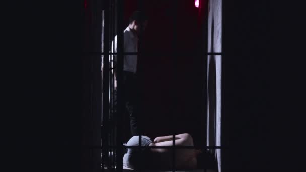 Skräckskådespeleri - fängelsedirektören hittar en förrymd man på sjukhuset och slår honom med fötterna på marken — Stockvideo