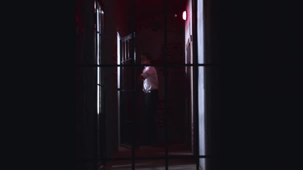 Horror aktorski - niebezpieczny strażnik uwalnia więźnia z celi trzymającego metalową rurę — Wideo stockowe