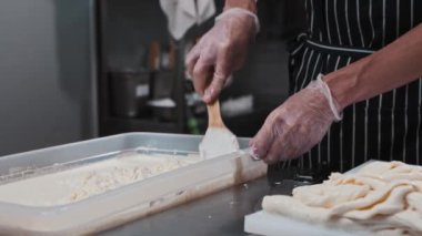 Taze mozzarella peyniriyle çalışan adam.