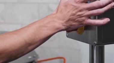 Peynir üretimi - erkek işçi peynir üretimi için makineyi kapatır ve bir fıçı açar