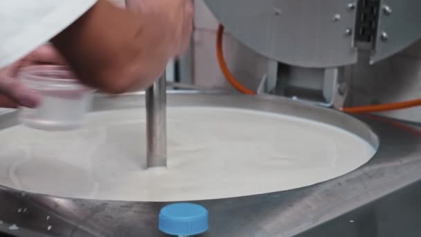 Ostproduktion - manlig arbetare som arbetar med ett kar med basen för ost - tillsättning av vatten — Stockvideo