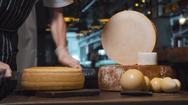 Peynir dükkanındaki bir adam koca bir peynir kafasını bıçakla ikiye böldü.