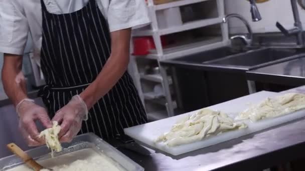 奶酪工厂工人将撕碎的软奶酪放入装有液体的容器中 — 图库视频影像
