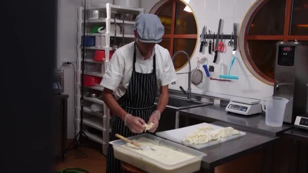 Fábrica de queso - trabajador del hombre poniendo trozos de queso blando en un recipiente con líquido — Vídeos de Stock