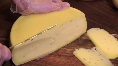 Restoran servisi. Adam, peynir kafasının bir parçasını bıçakla kesiyor.