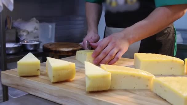 Ristorante che serve - uomo che taglia pezzi di formaggio a triangolo con un coltello — Video Stock