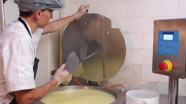 チーズ製造-チーズ製造機で作業する手袋の男-バットから余分な液体を除去します。 — ストック動画