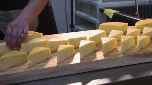 Un chef servant des morceaux de fromage triangle sur le bureau — Video