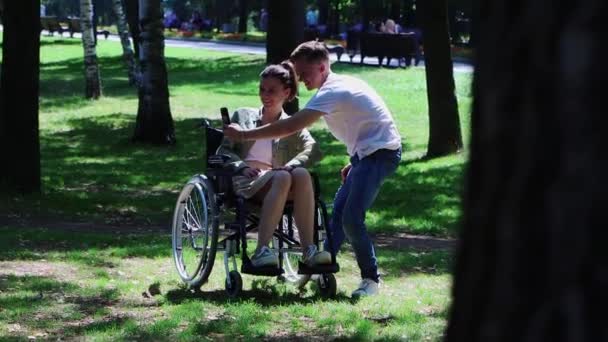 En kvinna i rullstol har en dejt med en kille - tar en selfie — Stockvideo