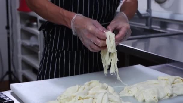 Cheese factory - man worker in gloves rips soft cheese into pieces — Stock Video