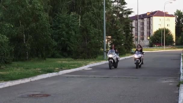 Zwei junge Frauen fahren am frühen Abend ohne Helm Motorrad — Stockvideo