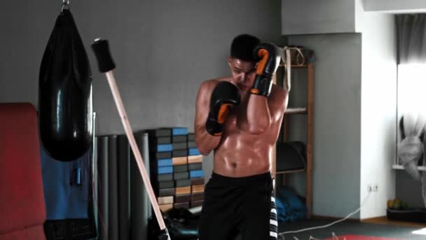 Trening bokserski - młody człowiek walczący kijem treningowym na siłowni — Wideo stockowe