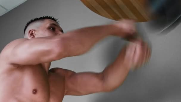 Тренування з боксу - без сорочки молодий чоловік ударяє маленький мішок перед обличчям на швидкості — стокове відео