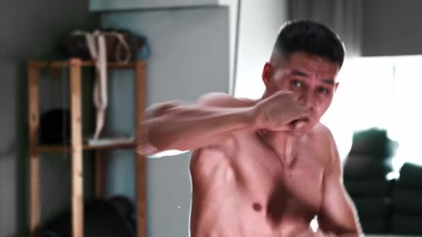 Тренування з боксу - без сорочки молодий чоловік, що виконує бої в тіні — стокове відео