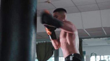 Gömleksiz genç adam boksör eğitimi alıyor.