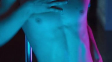 Genç çapkın bir adam, maske takmış, sahte elmaslarla dans ediyor ve seksi davranıyor.