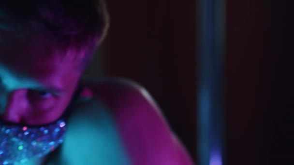 Een jonge flirterige man stripper acteren sexy in neon verlichting — Stockvideo