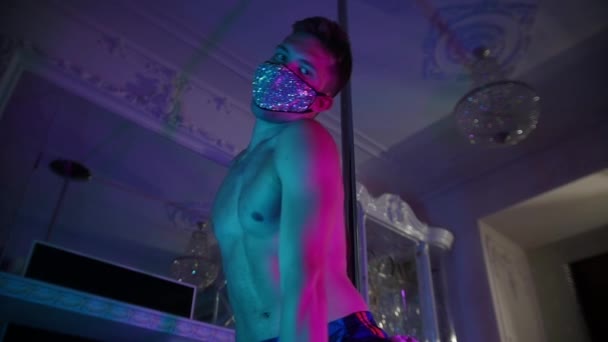 Giovane spogliarellista senza maglietta che balla sulla macchina fotografica in maschera coperta di strass - illuminazione al neon — Video Stock