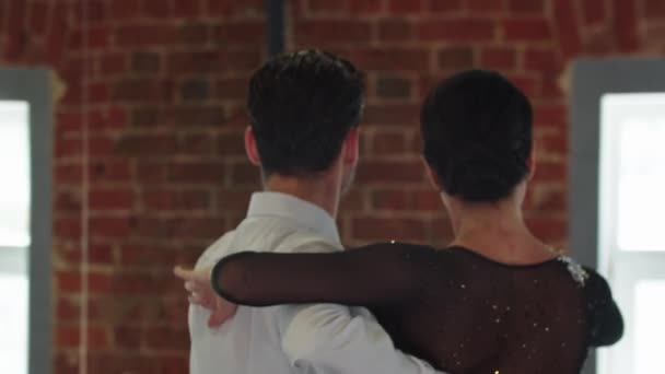 Danças latinas - homem e mulher treinando sua dança no estúdio com paredes de tijolo - o homem contando o andamento — Vídeo de Stock
