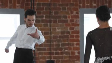 Kadın ve erkek stüdyoda duvarlarla Latin dansı yapıyor.