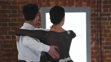 Kadın ve erkek kostümlerini giyip stüdyoda dans ediyorlar.