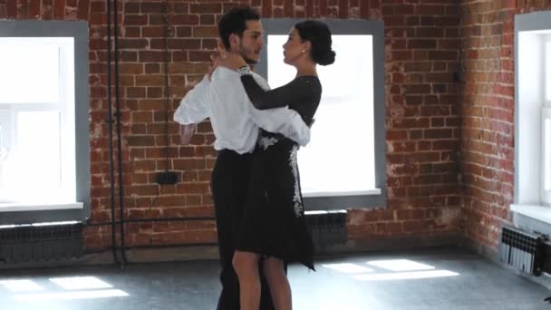 Hombre y mujer en la realización de trajes de entrenamiento de su número de baile en el estudio con paredes de ladrillo — Vídeos de Stock