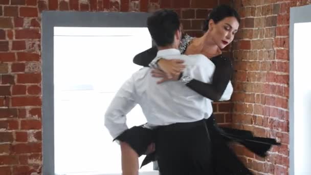 衣装を着て男と女はスタジオでアクロバティックな要素を持つ彼らのダンス番号を訓練 — ストック動画