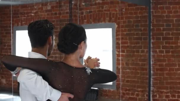 Un couple en costumes de performance formant leur numéro de danse dans le studio avec des murs de briques — Video