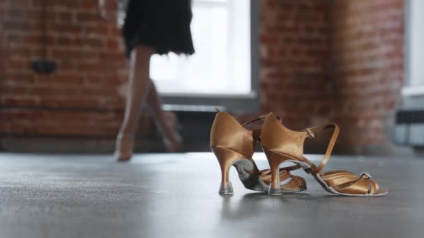 Una bailarina de zapatos amarillos camina hacia sus zapatos de reemplazo y los recoge. — Vídeos de Stock